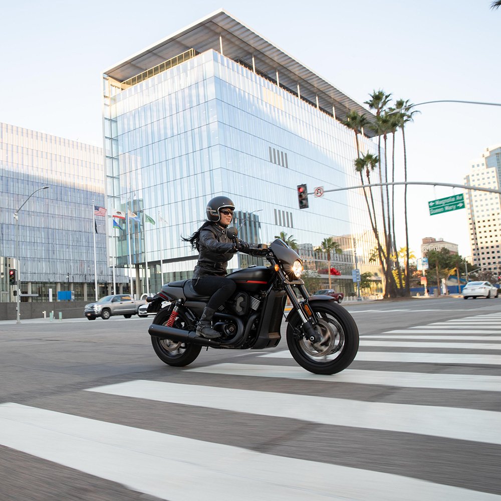 Woman riding a LiveWire motorcycle down a street.