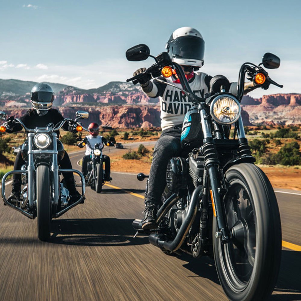 motorcycles riding on a highway in the desert